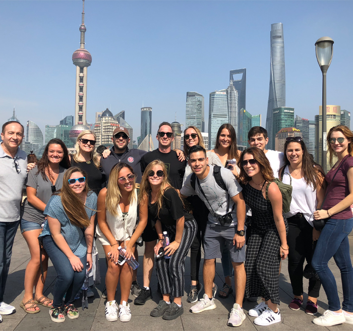 University of Tampa students posing in front of the China downtown skyline