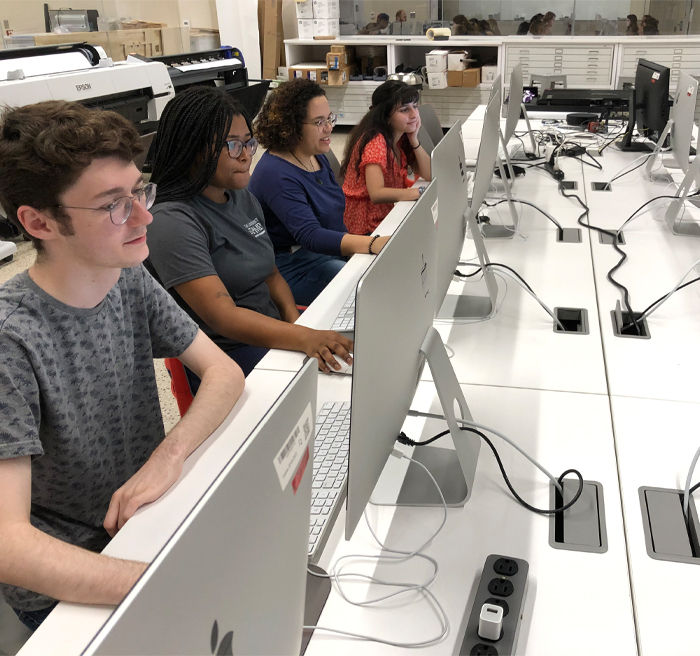 Students working at large Mac computers