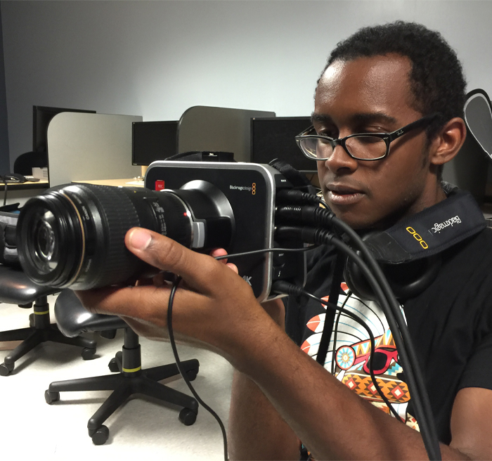 student working with camera in classroom 