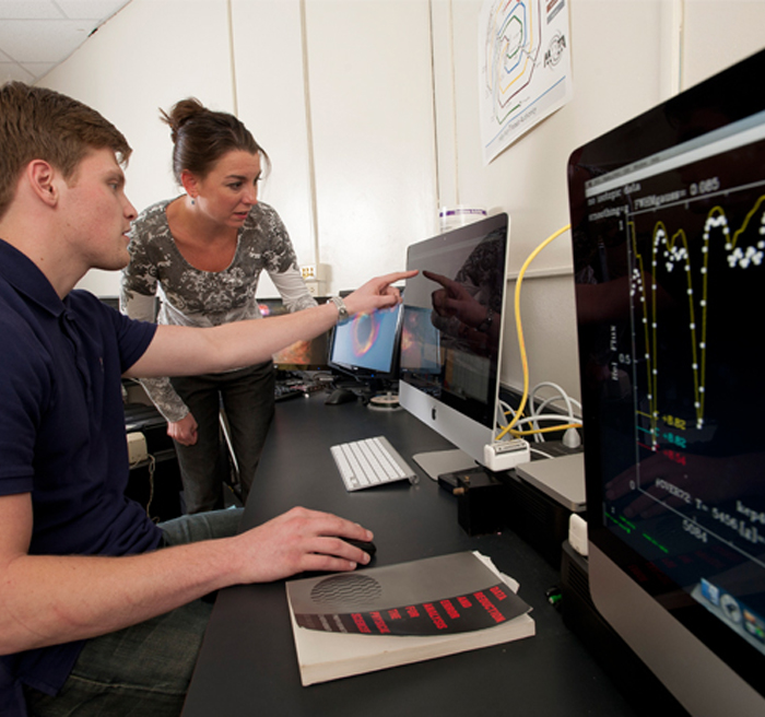 Students and professor working on computers 
