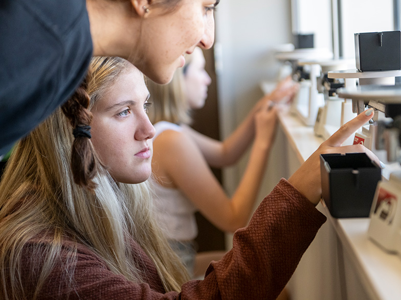 Student measuring material in a lab.