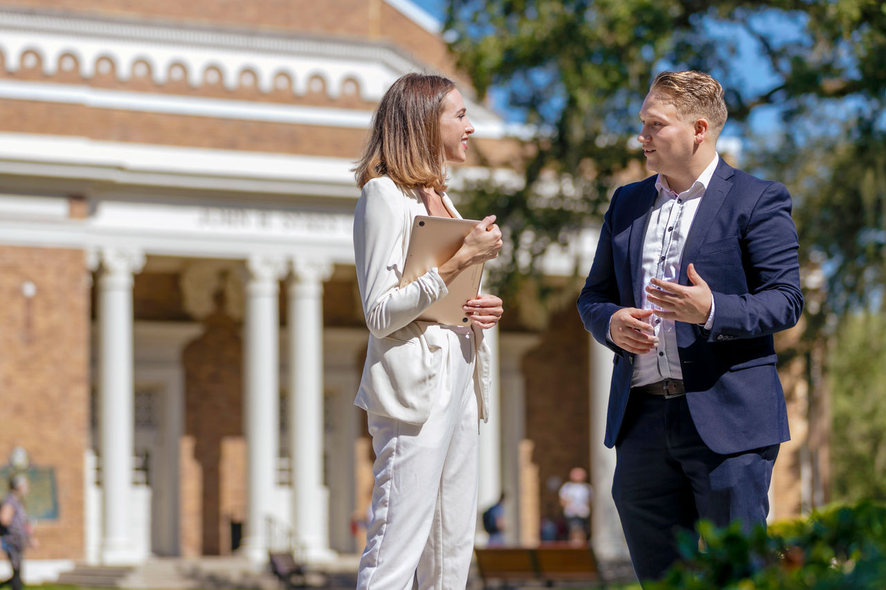 Two students outside of the College of Business building