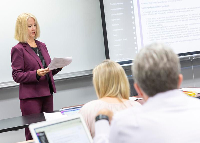 A faculty member works with a student at a computer.
