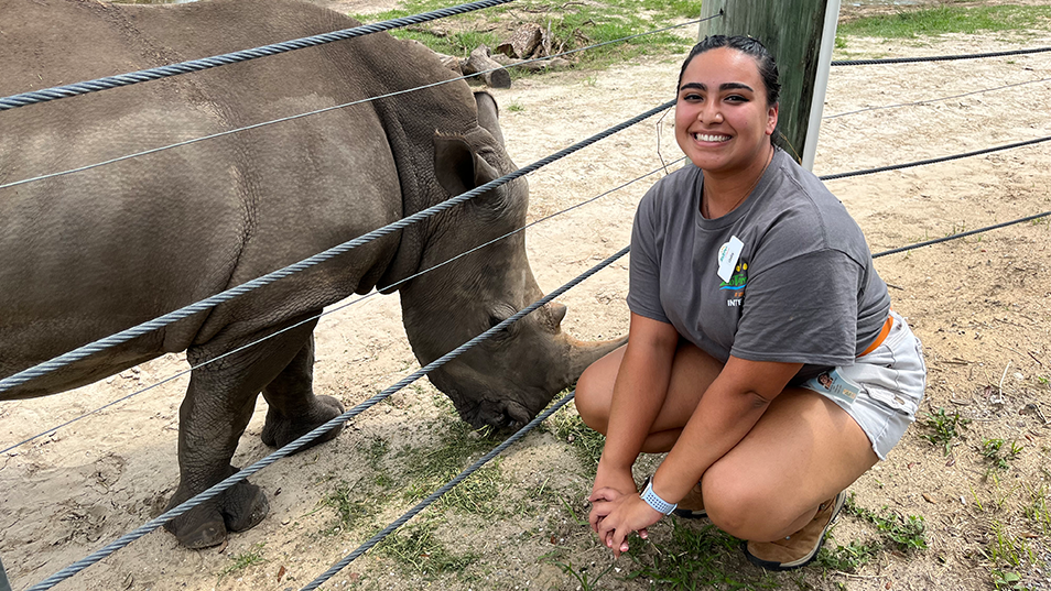 Students next to a rhinoceros 