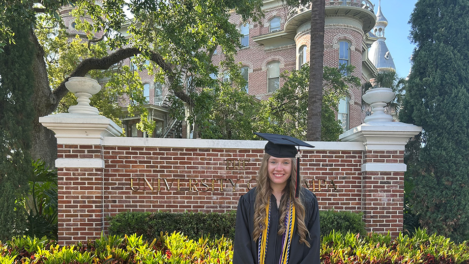 A student in front of the University of Tampa sign